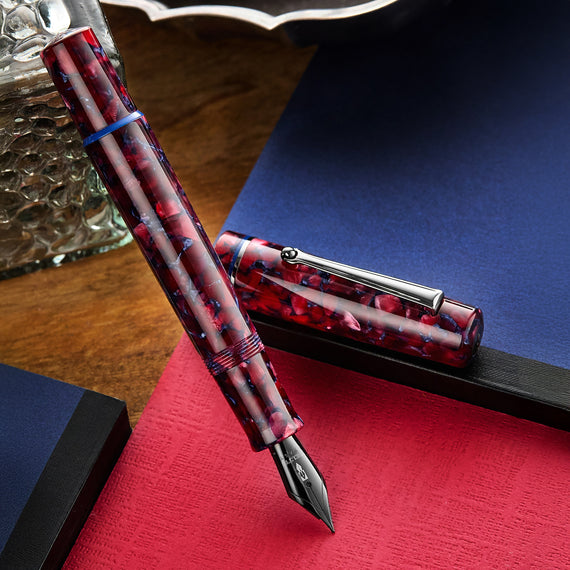 A Delta Spaccanapoli fountain pen with a flecked burgundy and blue resin body and gunmetal trim.