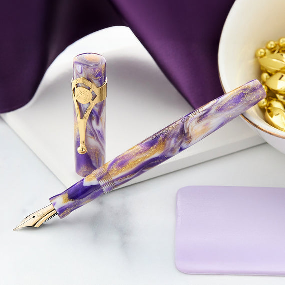 Purple and gold fountain pen on a white surface