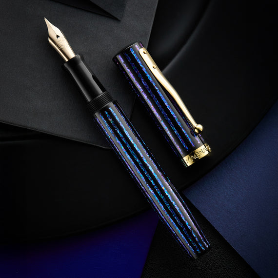 Fountain pen with blue and gold design on a dark background