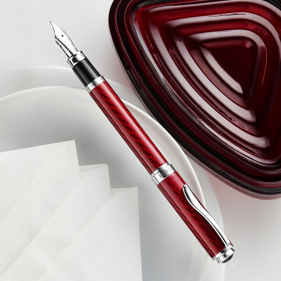 Red fountain pen with silver accents on a white background