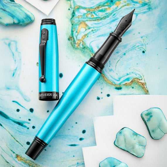 Blue fountain pen with black accents on a marble surface