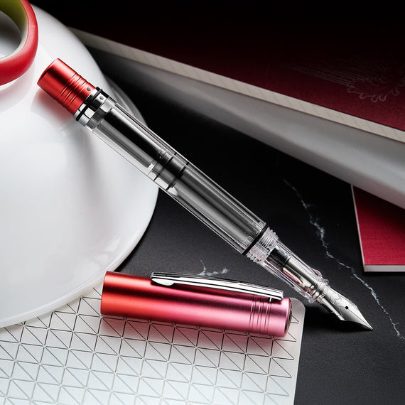 Fountain pen with red accents on a marble surface