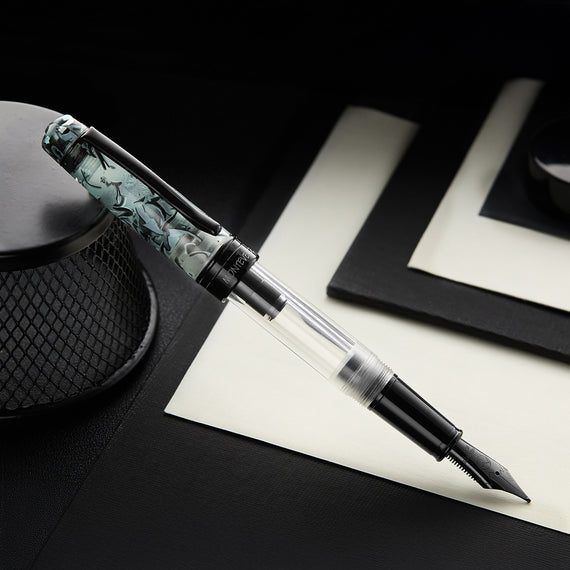 Fountain pen with decorative cap on a black surface
