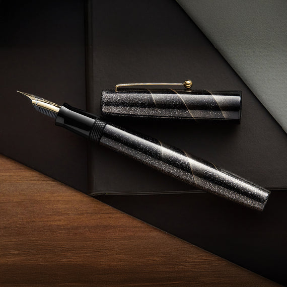 Fountain pen with black glittery finish on a dark surface