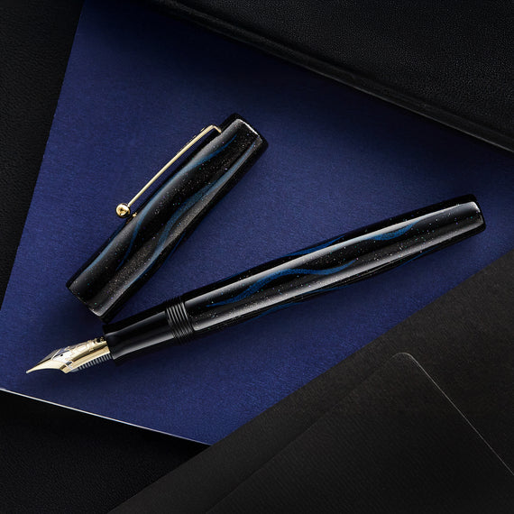 Fountain pen on a dark blue surface with a black case.