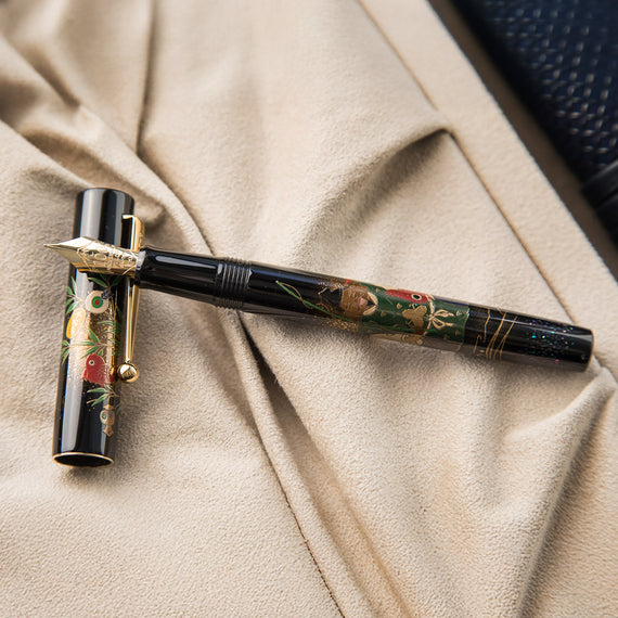 Decorative pen with floral designs on a beige fabric background