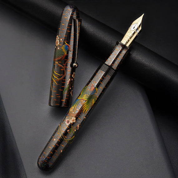 Decorative pen with floral and bird patterns on a black background
