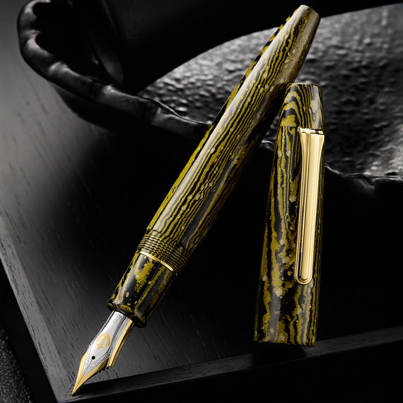 Fountain pen with gold accents on a dark textured surface