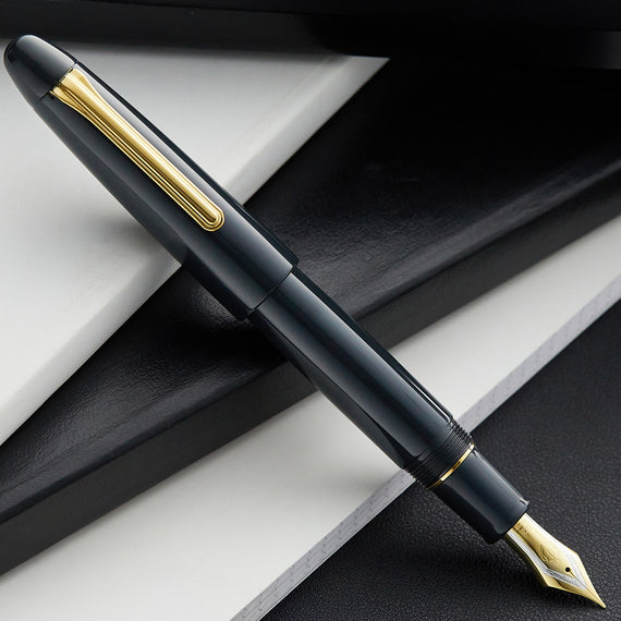 Dark blue fountain pen with gold accents on a dark surface