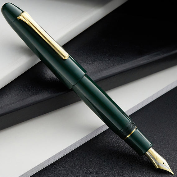 Green fountain pen with gold accents on a black and white background