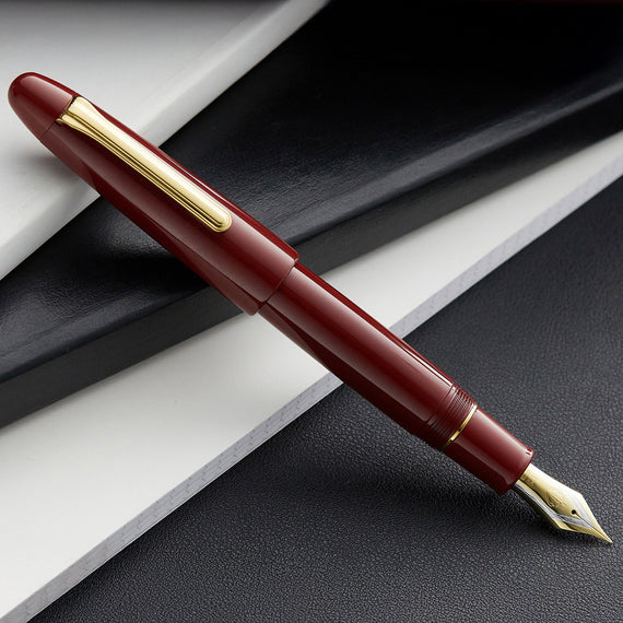 Maroon fountain pen with gold accents on a black and white background