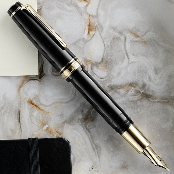 Black and gold fountain pen on a marble surface