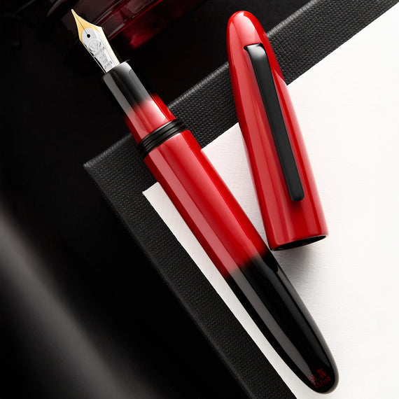 Red and black fountain pen on a dark background