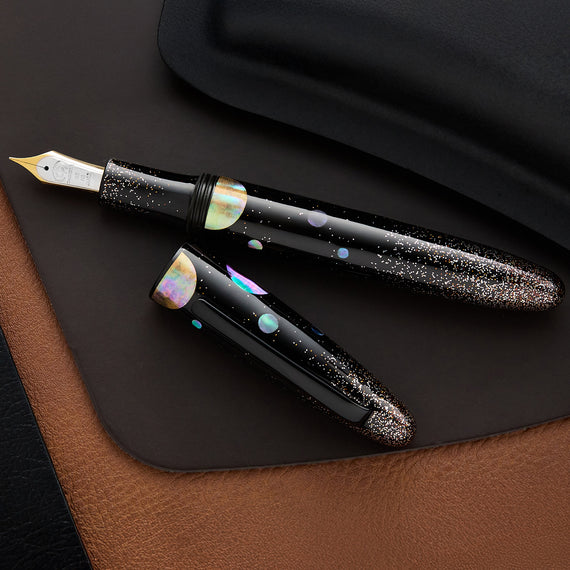 Fountain pen with decorative cap on a dark surface